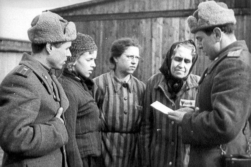 Russische soldaten in gesprek met gevangenen in Auschwitz.