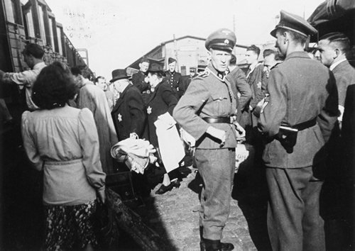 Westerbork: Onder toeziend oog van SS'ers stappen Joden in een trein die hen naar een vernietigingskamp in Duitsland zal brengen.