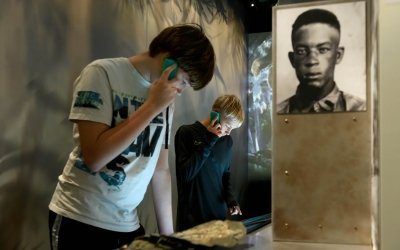 Een bezoeker in het museum met een audiotour apparaat