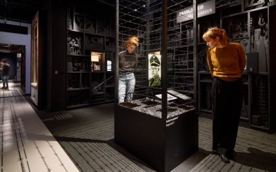 Twee bezoekers kijken naar een vitrine met prikkeldraad