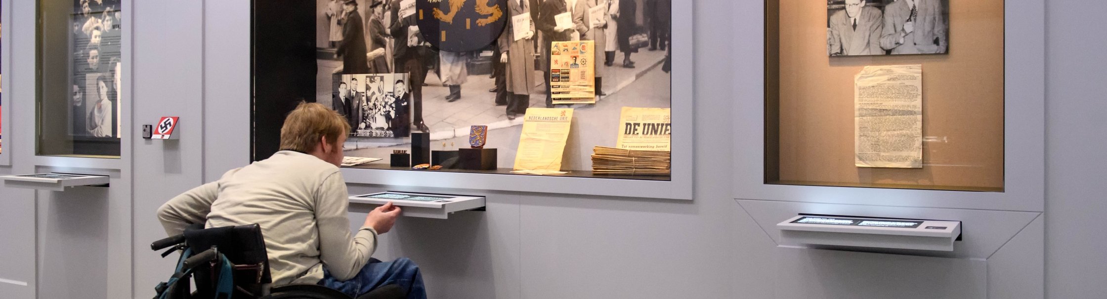 Een bezoeker in een rolstoel bezoekt het museum