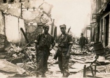 Nederlandse militairen bij de ruïnes van een Chinese wijk, januari 1947. Chinezen werden door de Indonesiërs als pro-Nederlands beschouwd. Hun huizen en winkels worden vaak in brand gestoken