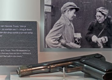 Vitrine met pistool van Hannie en foto van Hannie (rechts) en Truus na een actie.