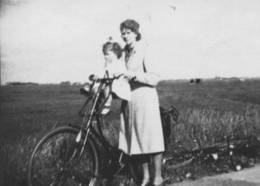 Vrouw met een kind op haar fiets.